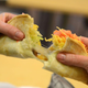 Person pulling apart cheesy Quesalupa